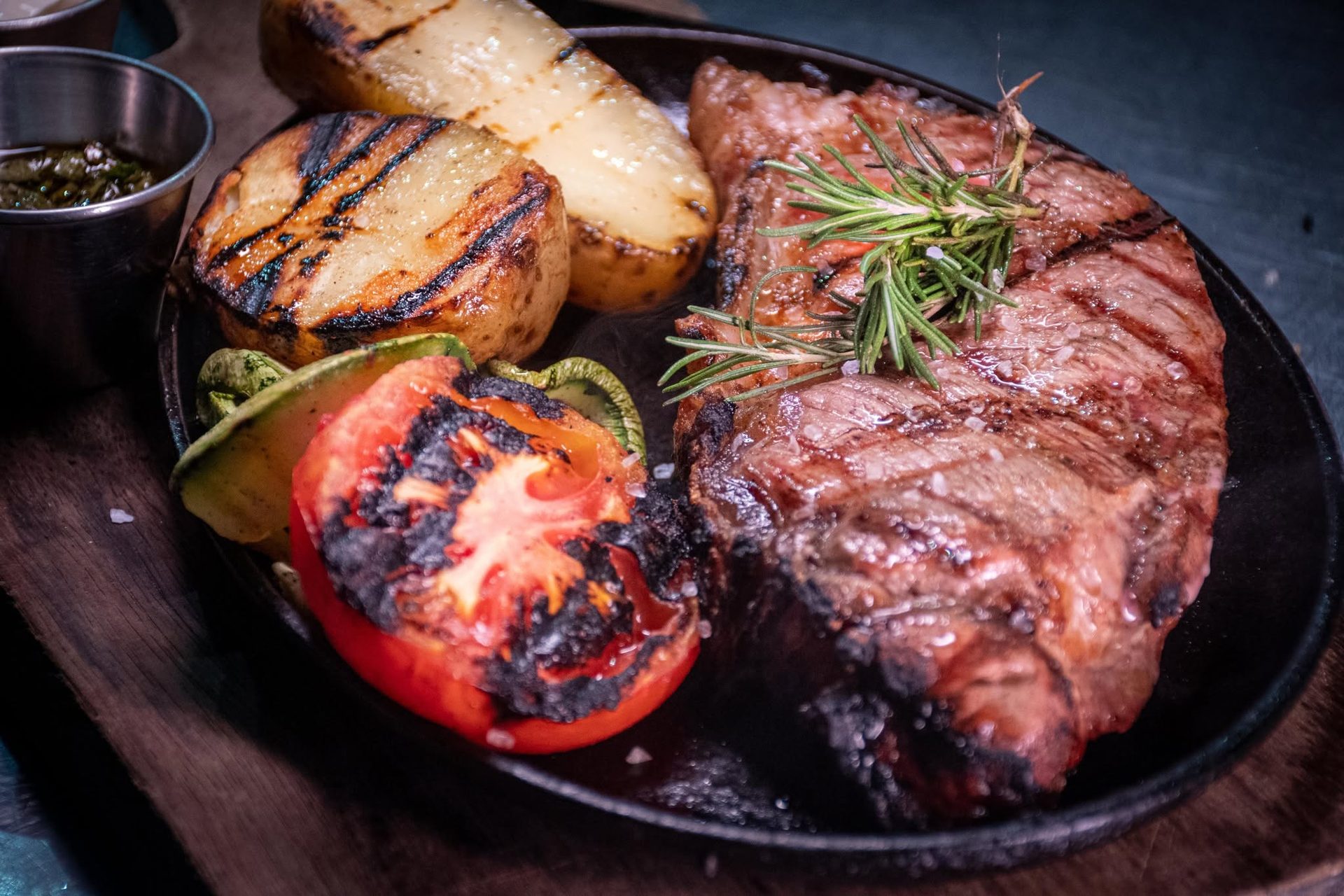 Bife al hierro con papas y lata de chimichurri