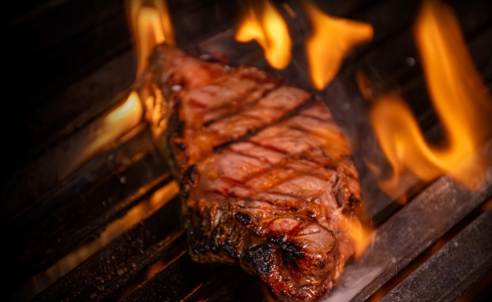 Corte de carne sobre el fuego vivo de la parrilla