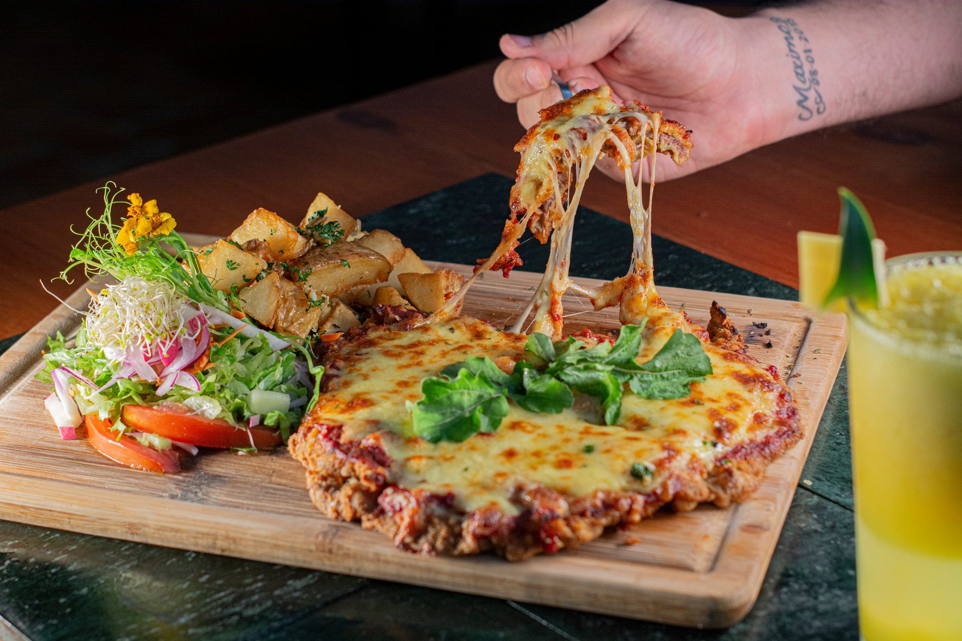 Milanesa napolitana con queso fundido estirándose en el tenedor